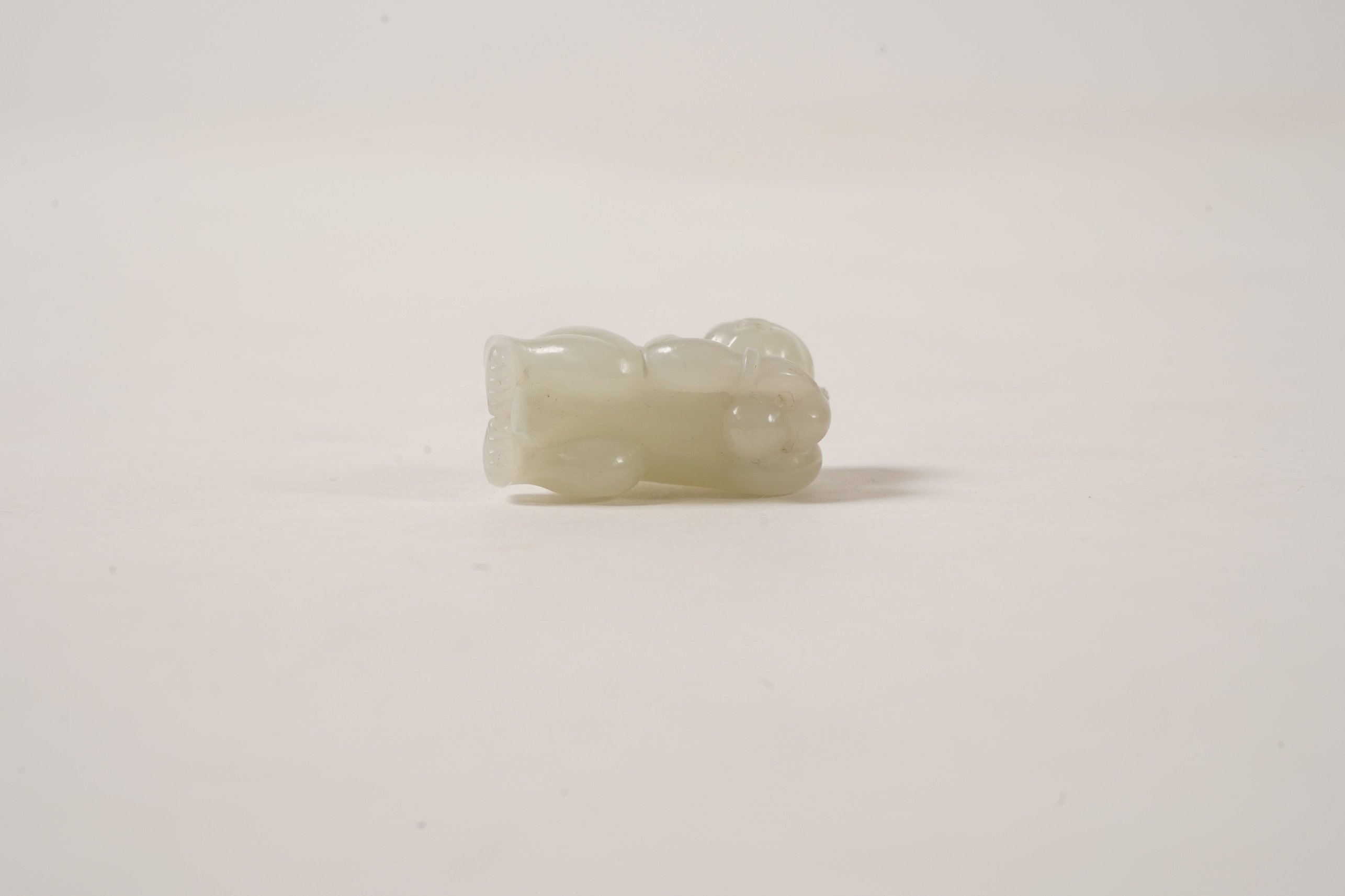 A Chinese white jade figure of a crouching boy, 19th/20th century